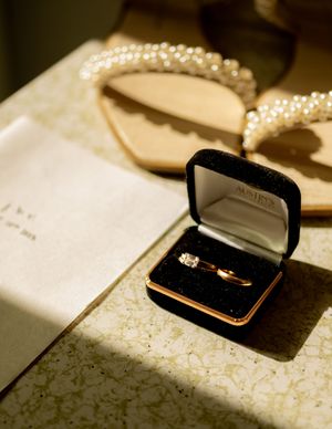 Wedding rings in black velvet box with dramatic lighting and text overlay.