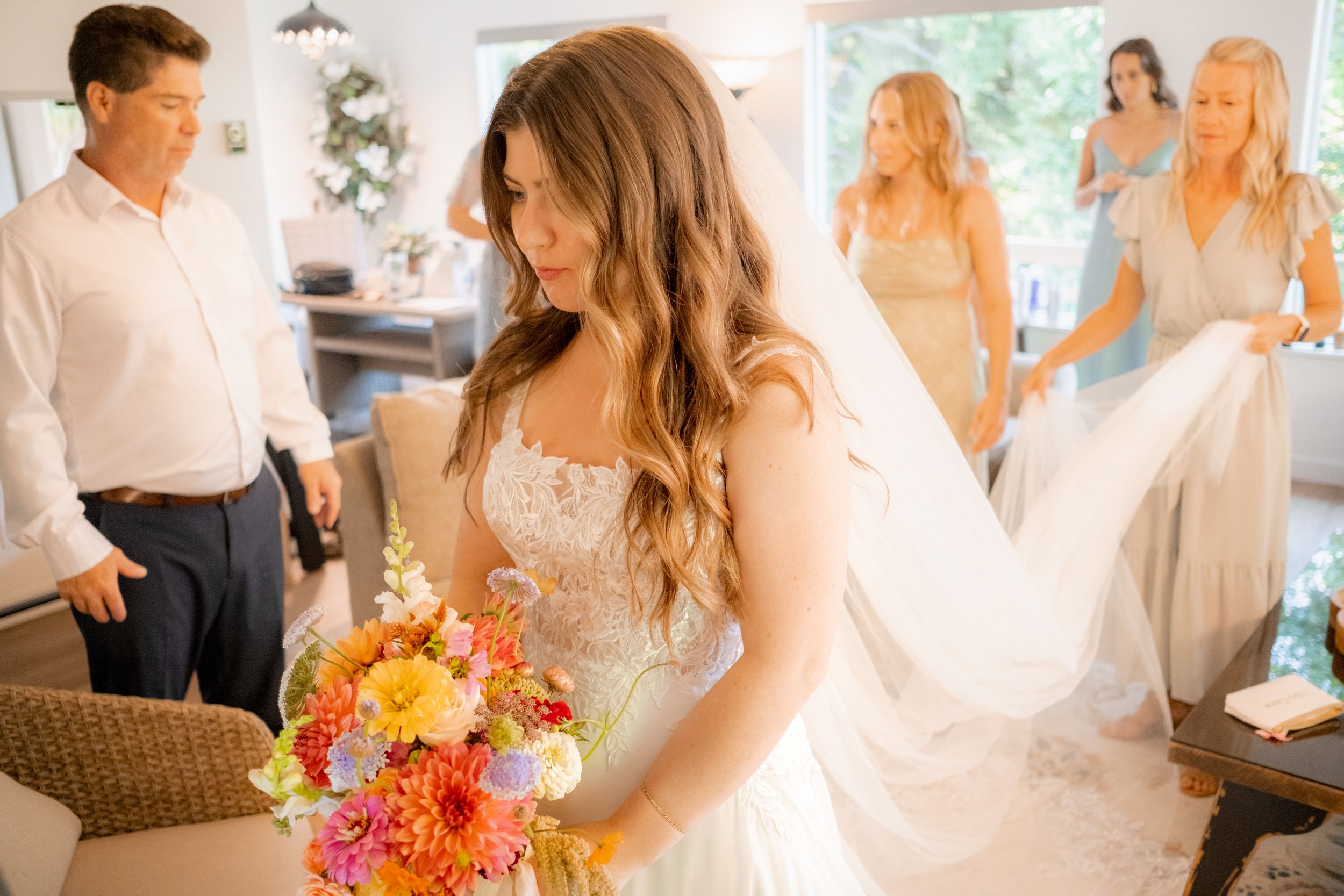 Natural light indoor photos showing joyful wedding preparation moments with friends and family.