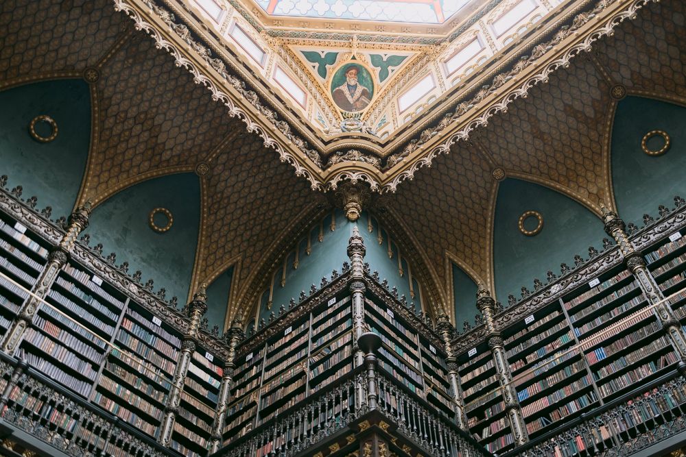 Stunning interior of a grand historic library with tall bookshelves and ornate painted ceiling.