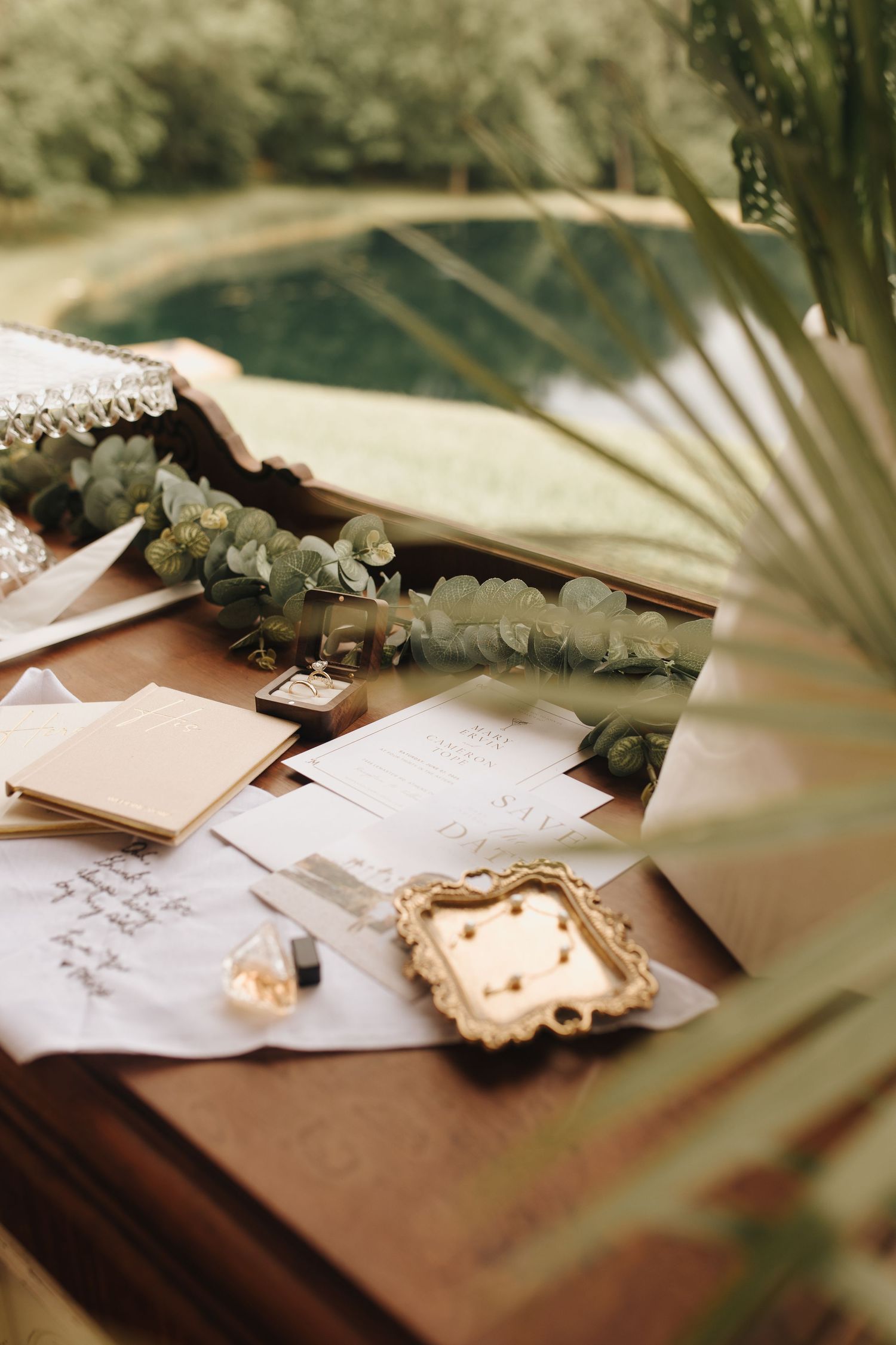 Stationary and foliage arranged artistically with papers, dried leaves, and botanical elements on a wooden surface - OH wedding photographer