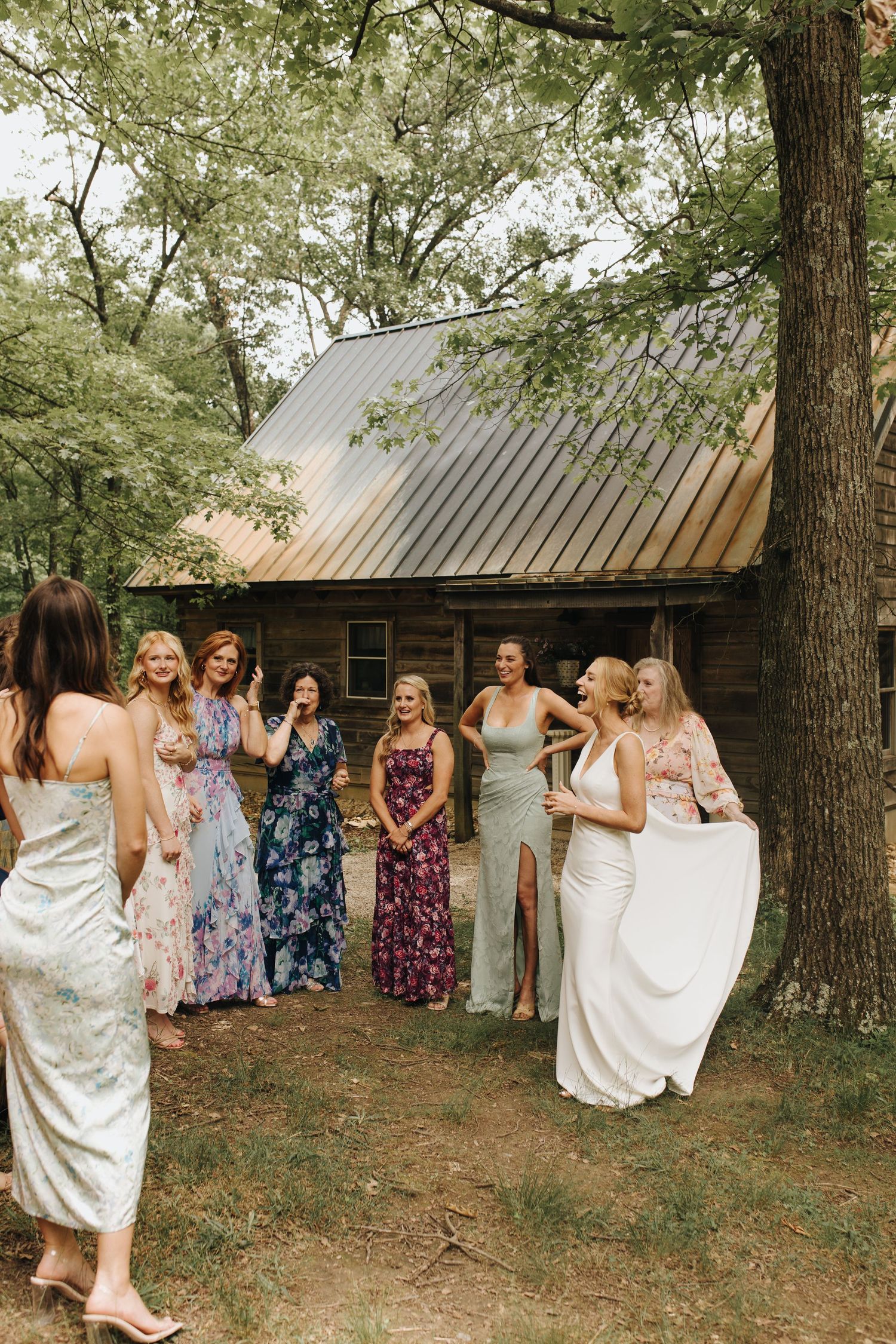Group of bridesmaids in mismatched dresses surrounding bride with excitement - Central Ohio wedding photographer.
