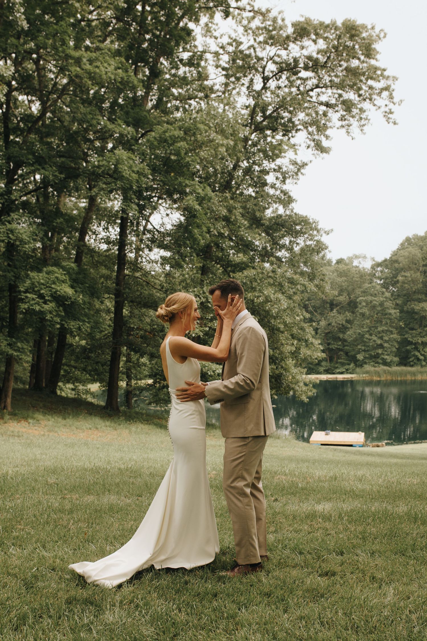 Groom getting emotional after seeing his bride in her wedding dress for the first time - bride wiping away his tears.