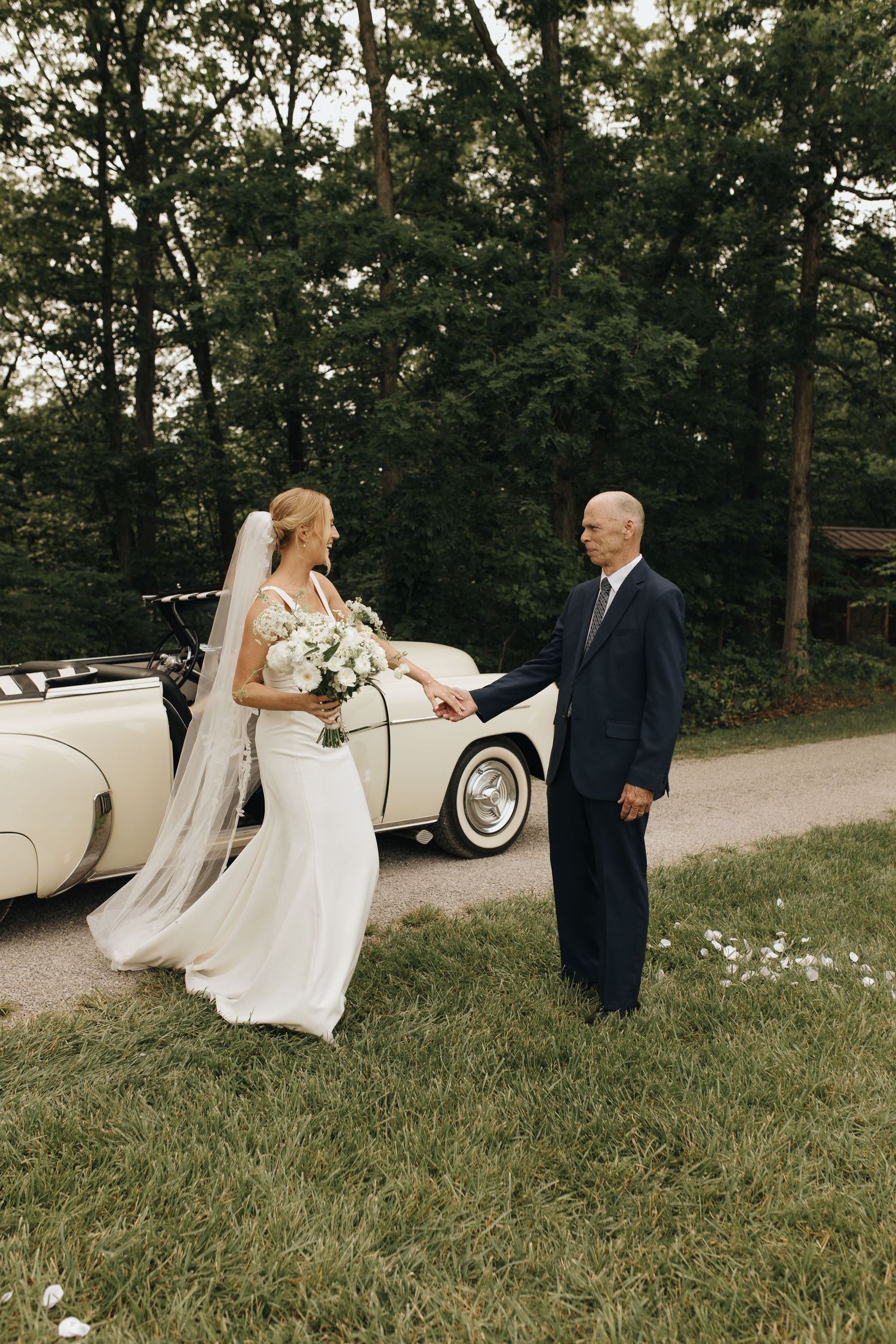 Vintage car that arrived with the bride, her father helping her out to walk down the aisle to her groom.