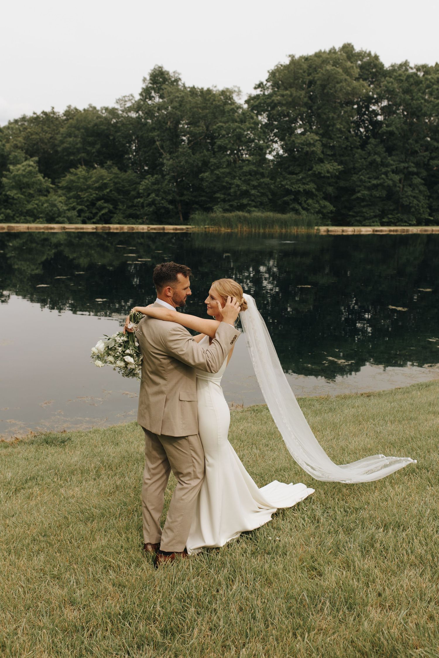 Candid photo of newlyweds embracing each other during backyard wedding portraits.