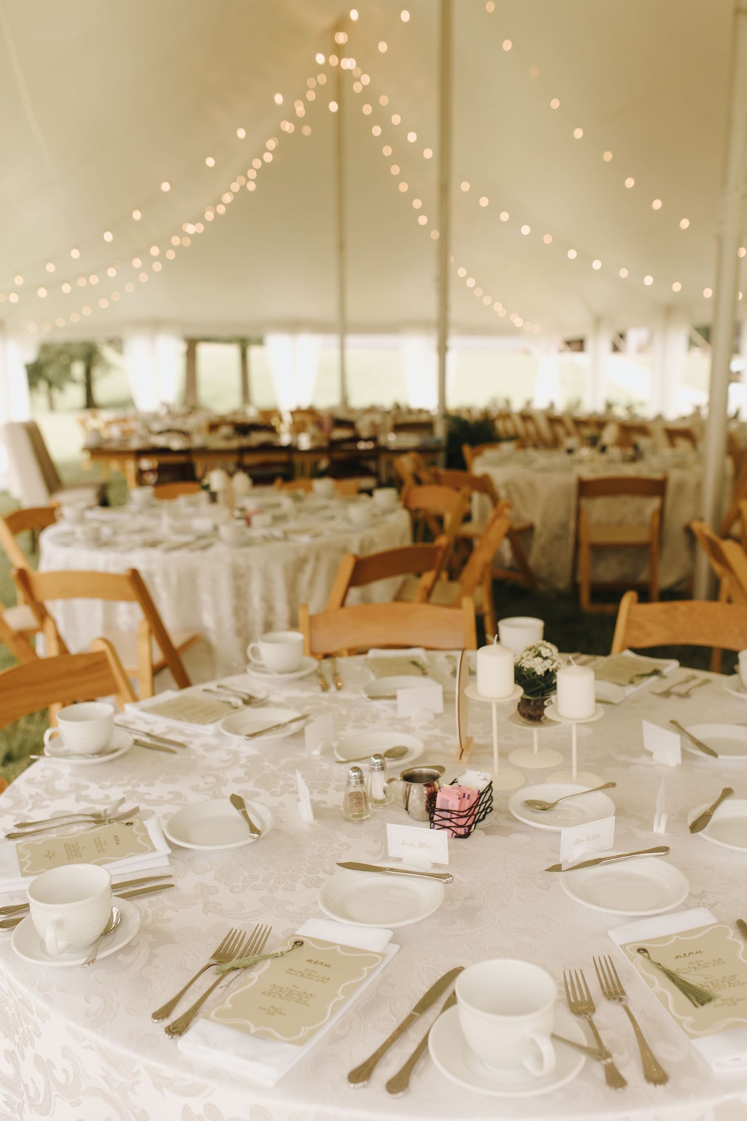 Outdoor backyard wedding reception tables with soft neutral linens and beautiful string lights hanging from the tent, Southeast Ohio wedding