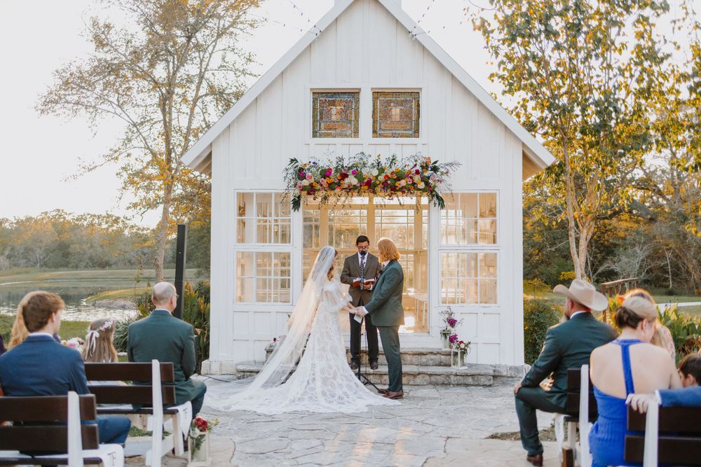 Beautiful white chapel wedding venue surrounded by autumn trees at sunset.