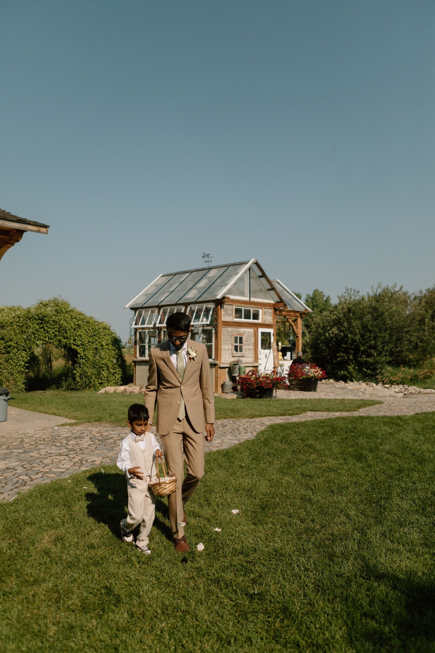A tender moment between parent and child on a lawn with a rustic cottage in the background.