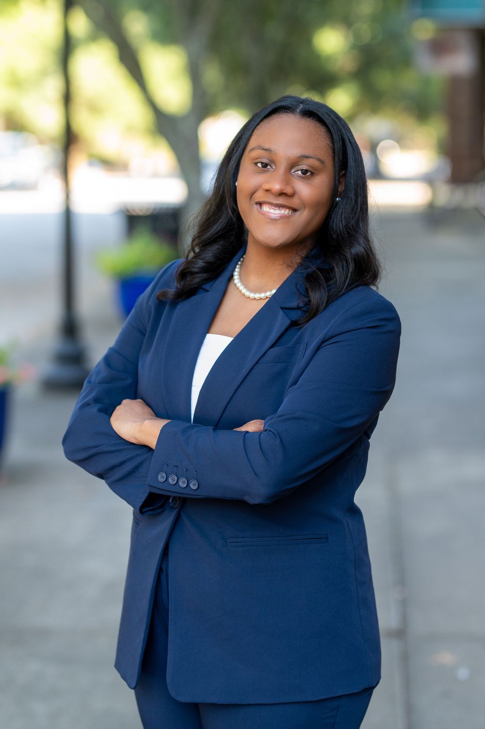 Professional portrait series showing person in navy business attire against outdoor setting.