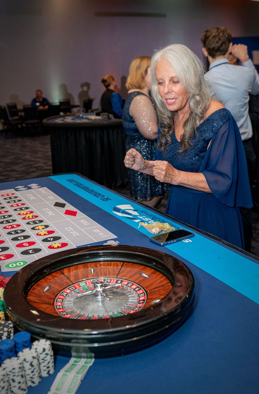 Casino-themed event setup with roulette wheels and gaming tables decorated in blue and black.