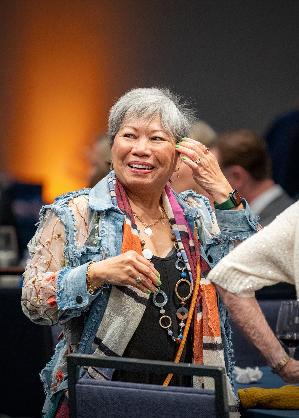Woman in a patterned outfit gestures while participating in a casino-style charity event.