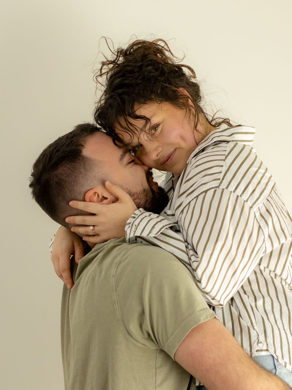 An intimate moment captured between two people in contrasting striped and solid clothing.