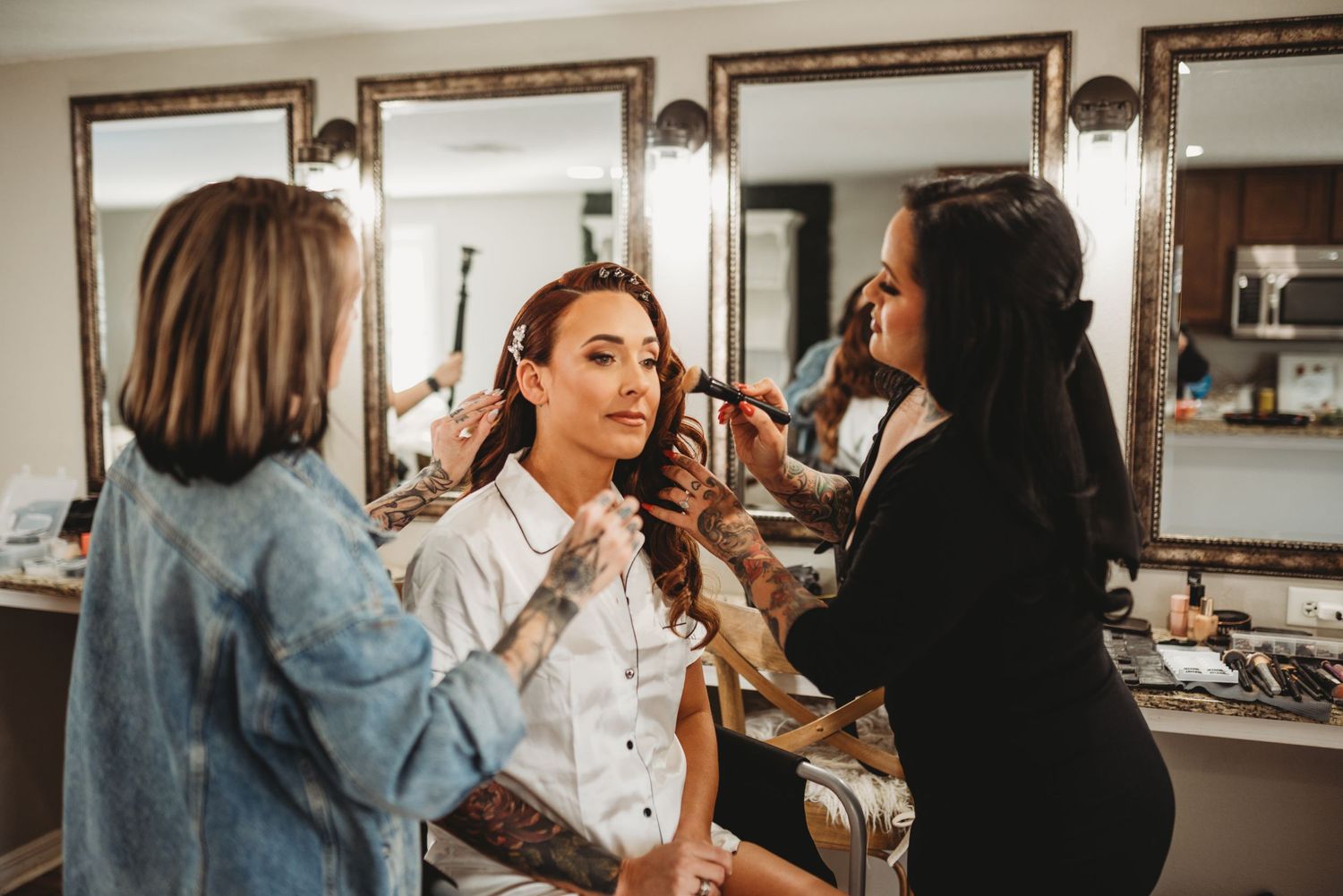 Getting ready scene in a makeup room with styling preparations underway.