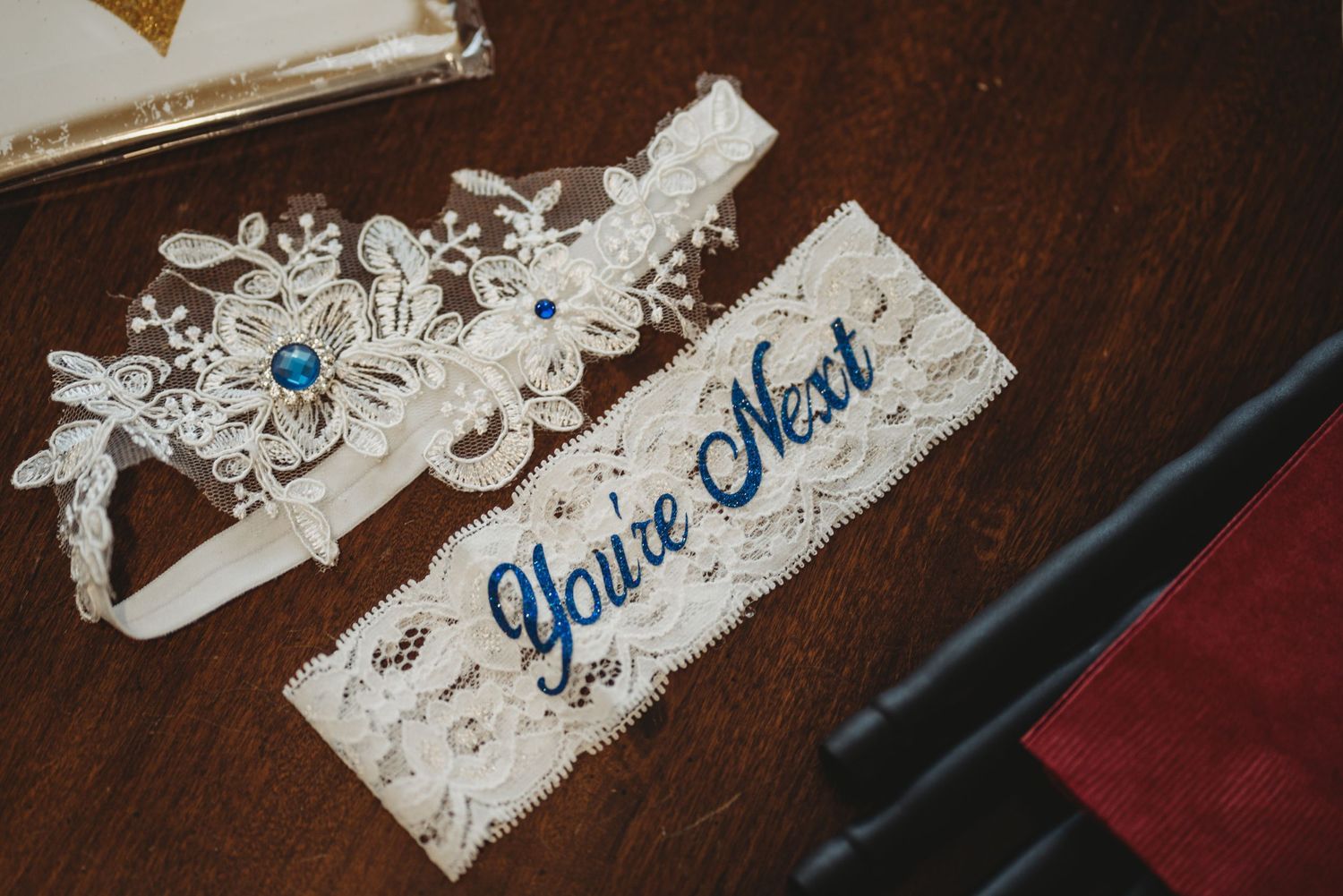 Wedding garter and name tag with blue text on lace detailing.
