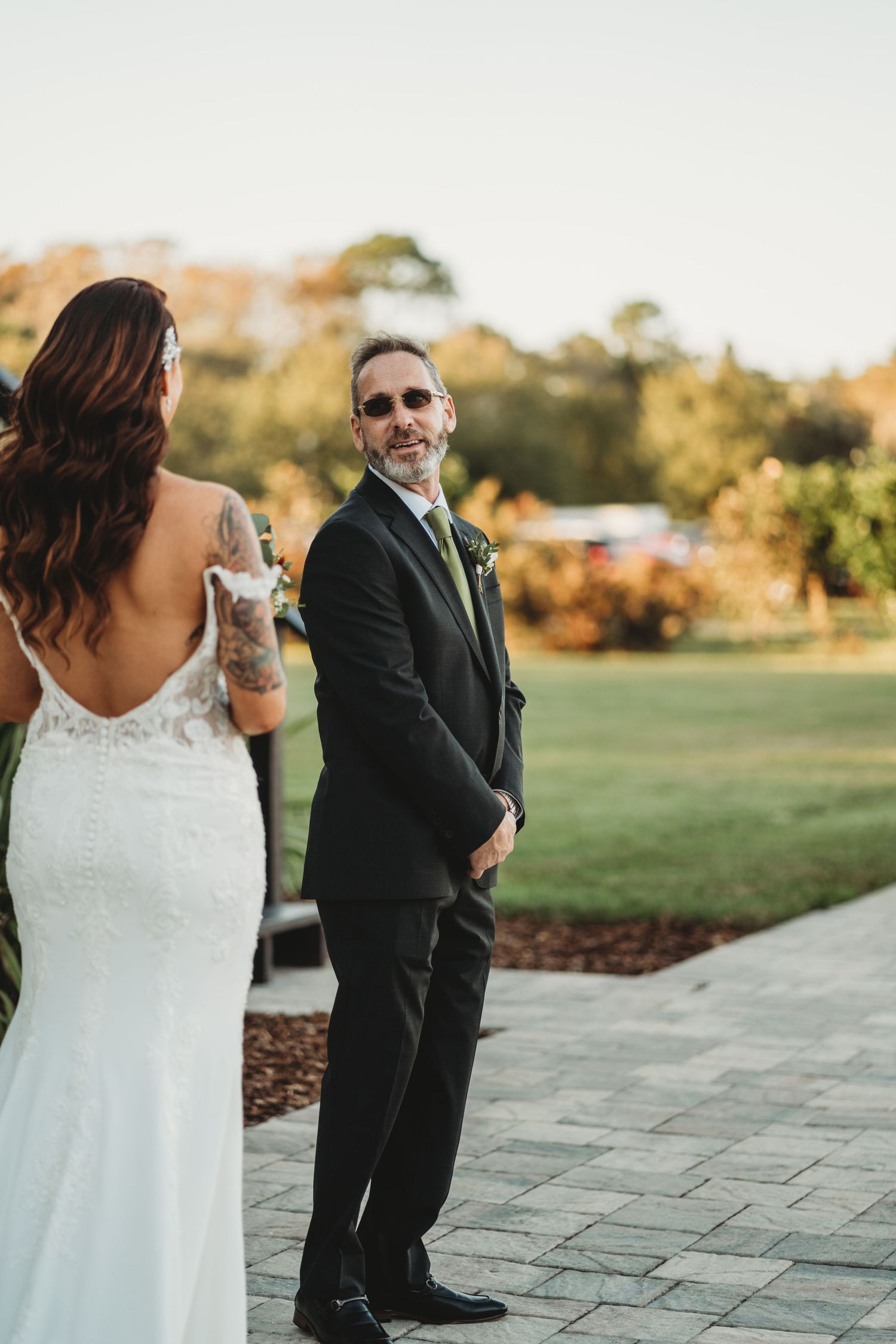 First look moment captured between couple on stone pathway during golden hour.