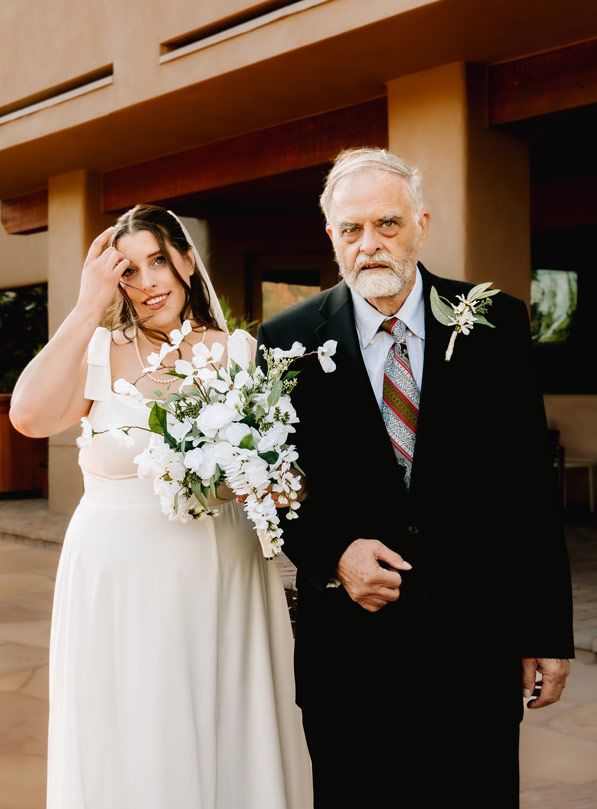A bride and her father pause for a photo before the wedding ceremony.