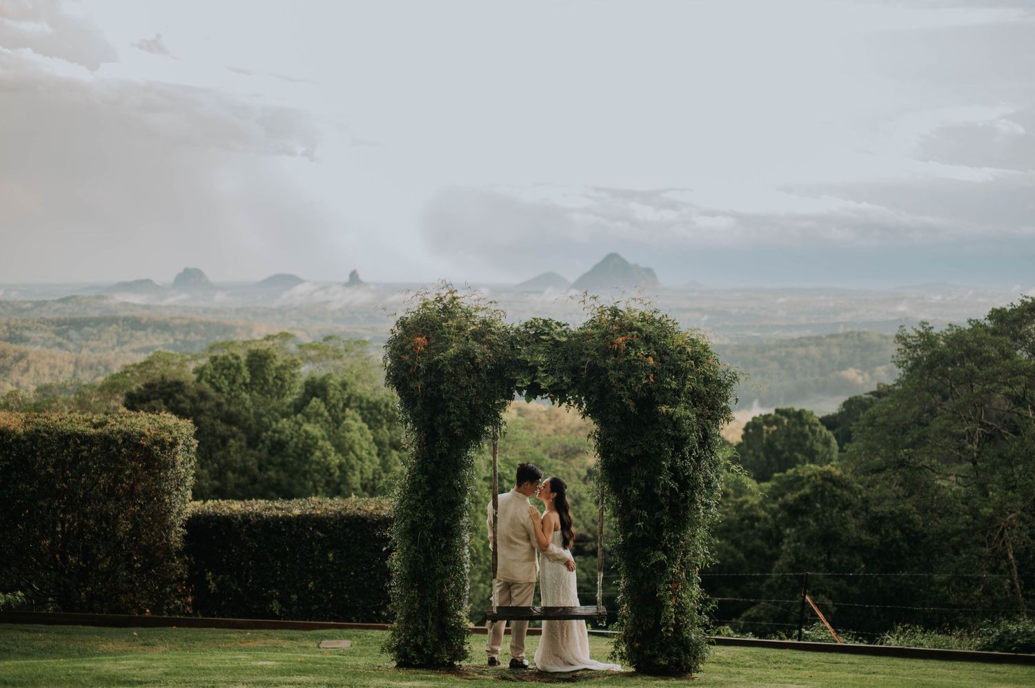 Garden wedding arch with mountain vista in background during sunset.