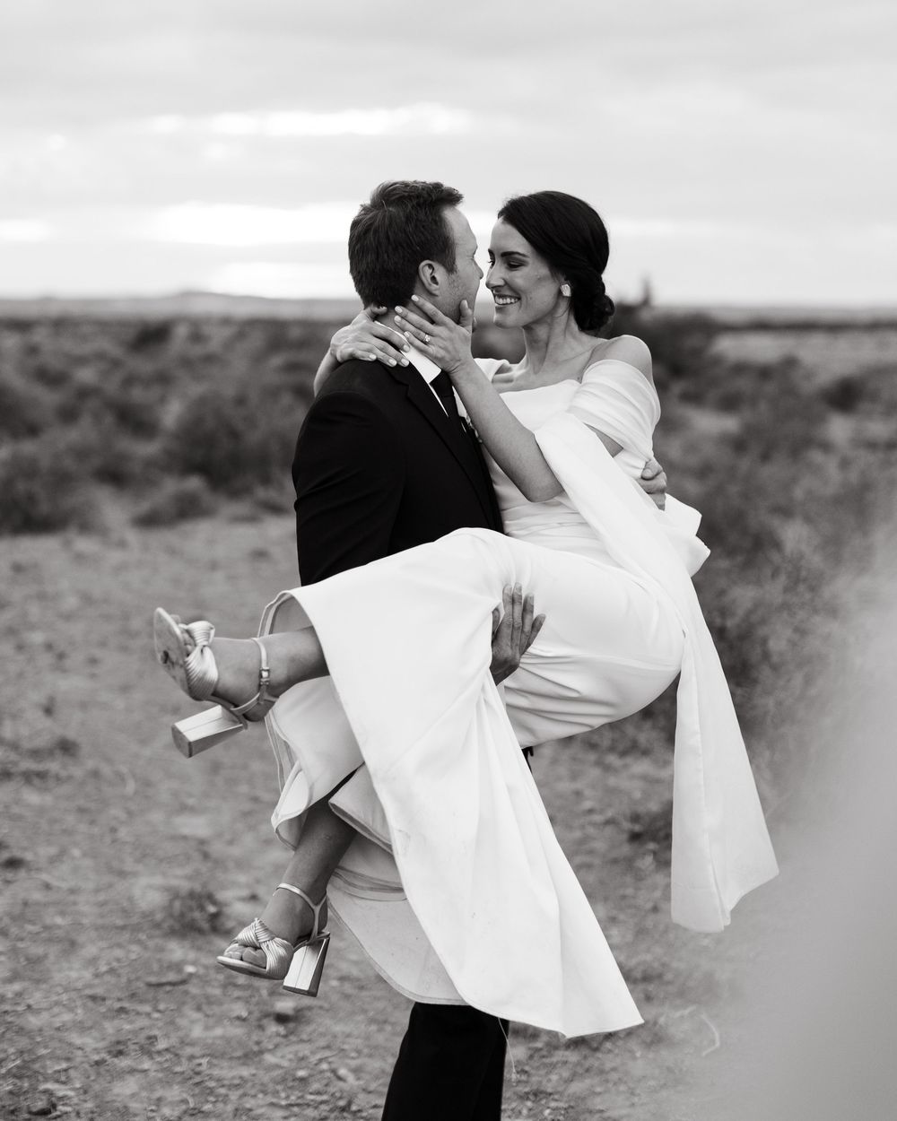 A romantic black and white wedding photo series showing a couple embracing and dancing in an outdoor setting.