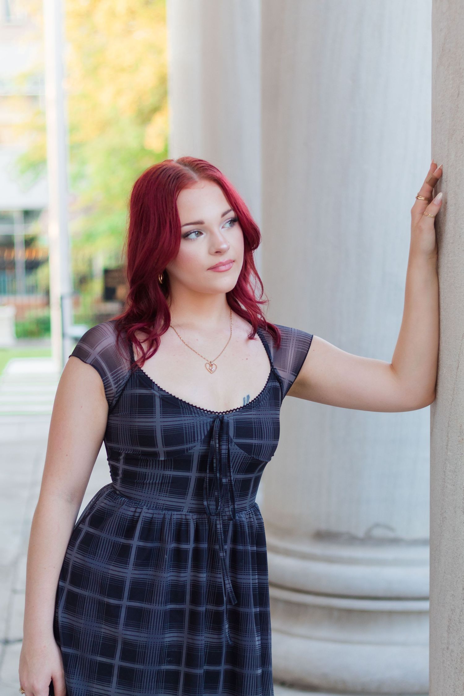Senior leaning against column