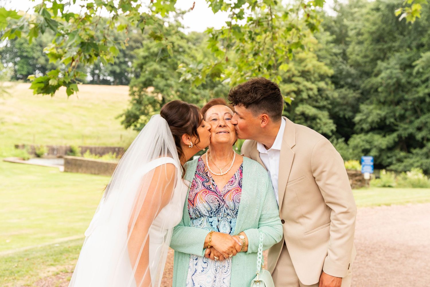 A tender moment shared during wedding celebrations in a sunny garden setting.