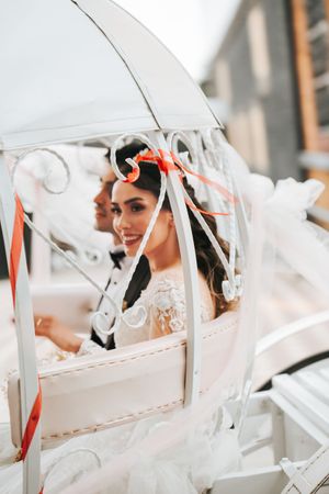 Decorated carriage with white and coral ribbons creating a romantic wedding scene.