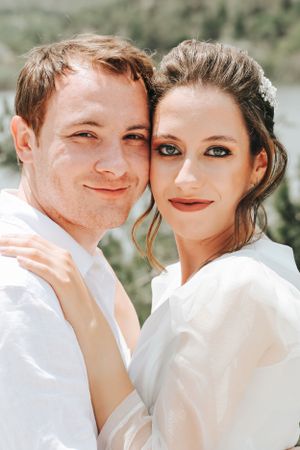Wedding portrait showing a tender moment between newlyweds in bright natural sunlight.