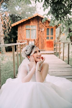 A joyful wedding portrait taken on a wooden walkway leading to a rustic cabin.