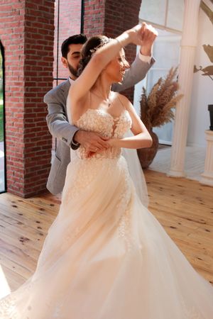 A romantic wedding dance captured mid-twirl in a rustic brick venue.