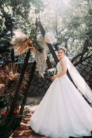 A wedding dress captured in a garden setting with pampas grass and natural sunlight.