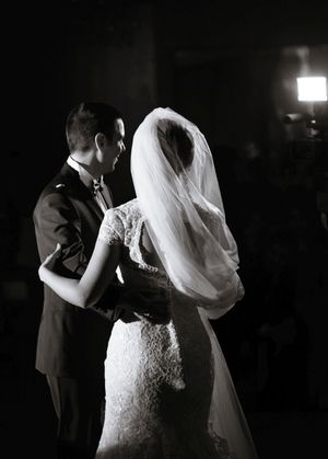 A romantic black and white photo captures a couple's first dance at their wedding reception.
