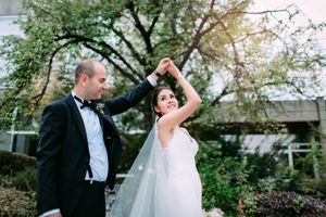 Joyful wedding dance moment captured in outdoor garden setting.