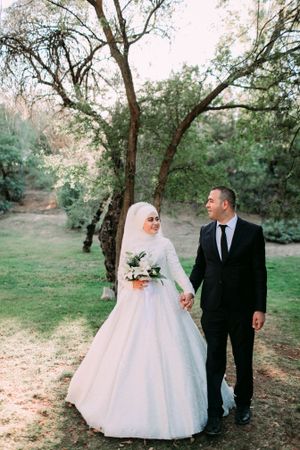A romantic wedding portrait in a wooded setting with natural lighting.