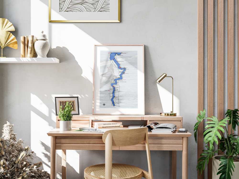 Modern home office nook with wooden desk, tan chair, wall art, and indoor plants in natural sunlight.