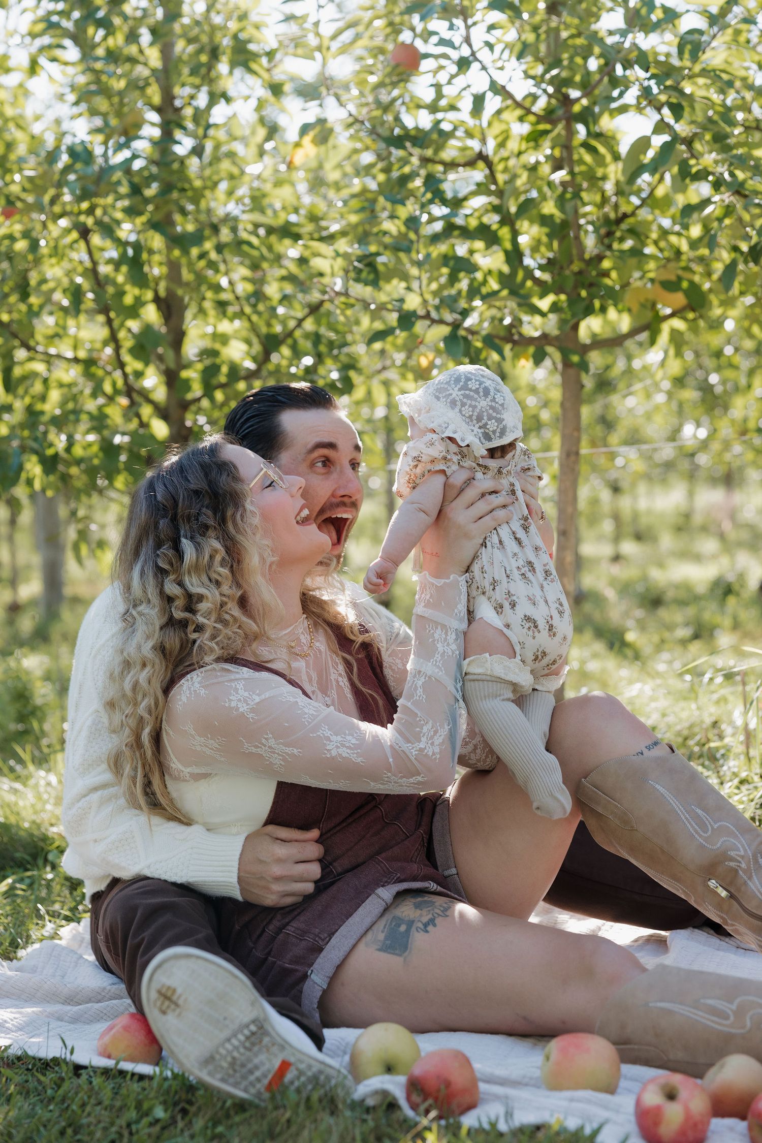 Young family smiling with baby at Lynd’s Orchard in Pataskala.