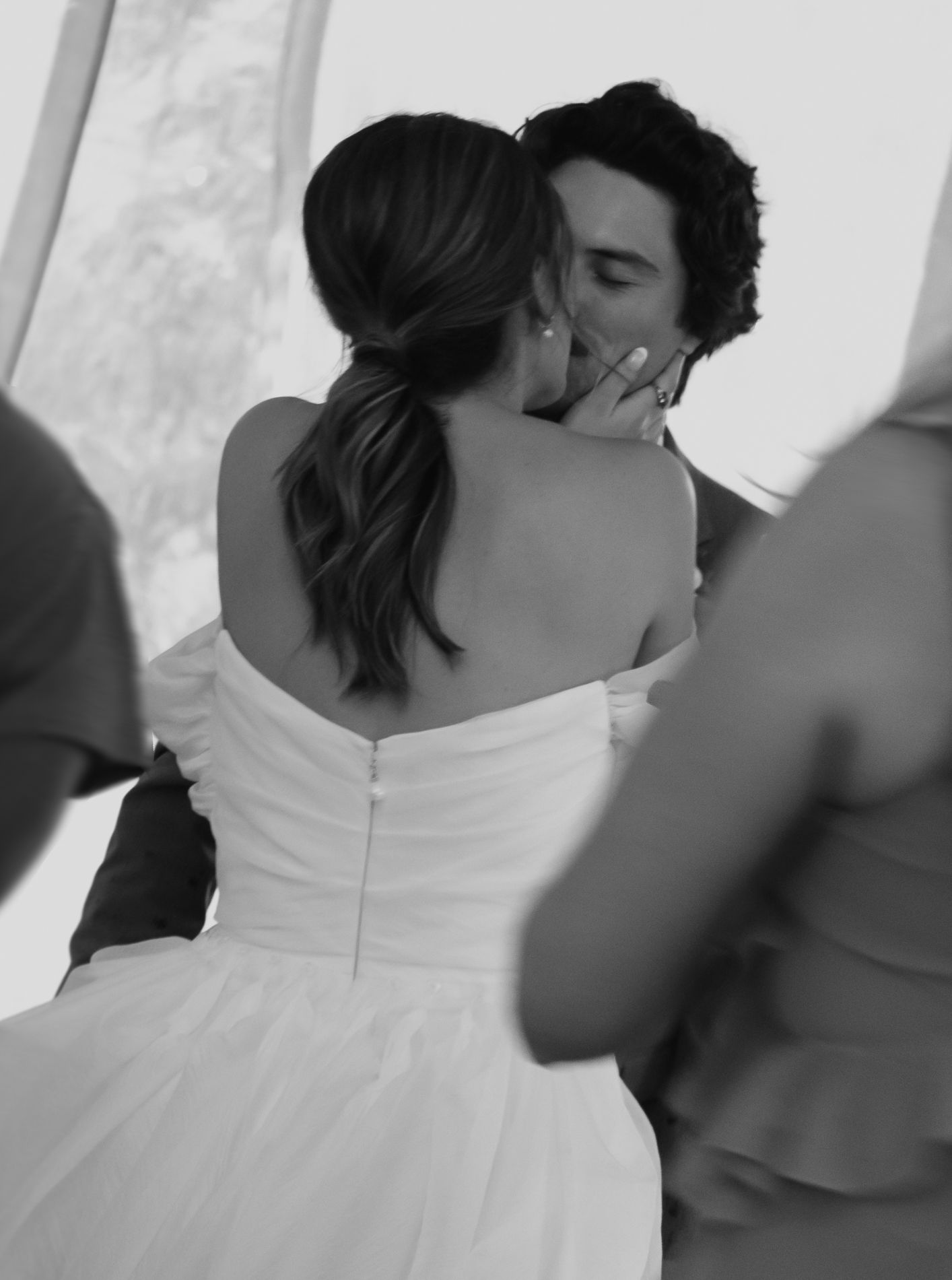 Black and white photo capturing an intimate moment between newlyweds at their wedding ceremony.
