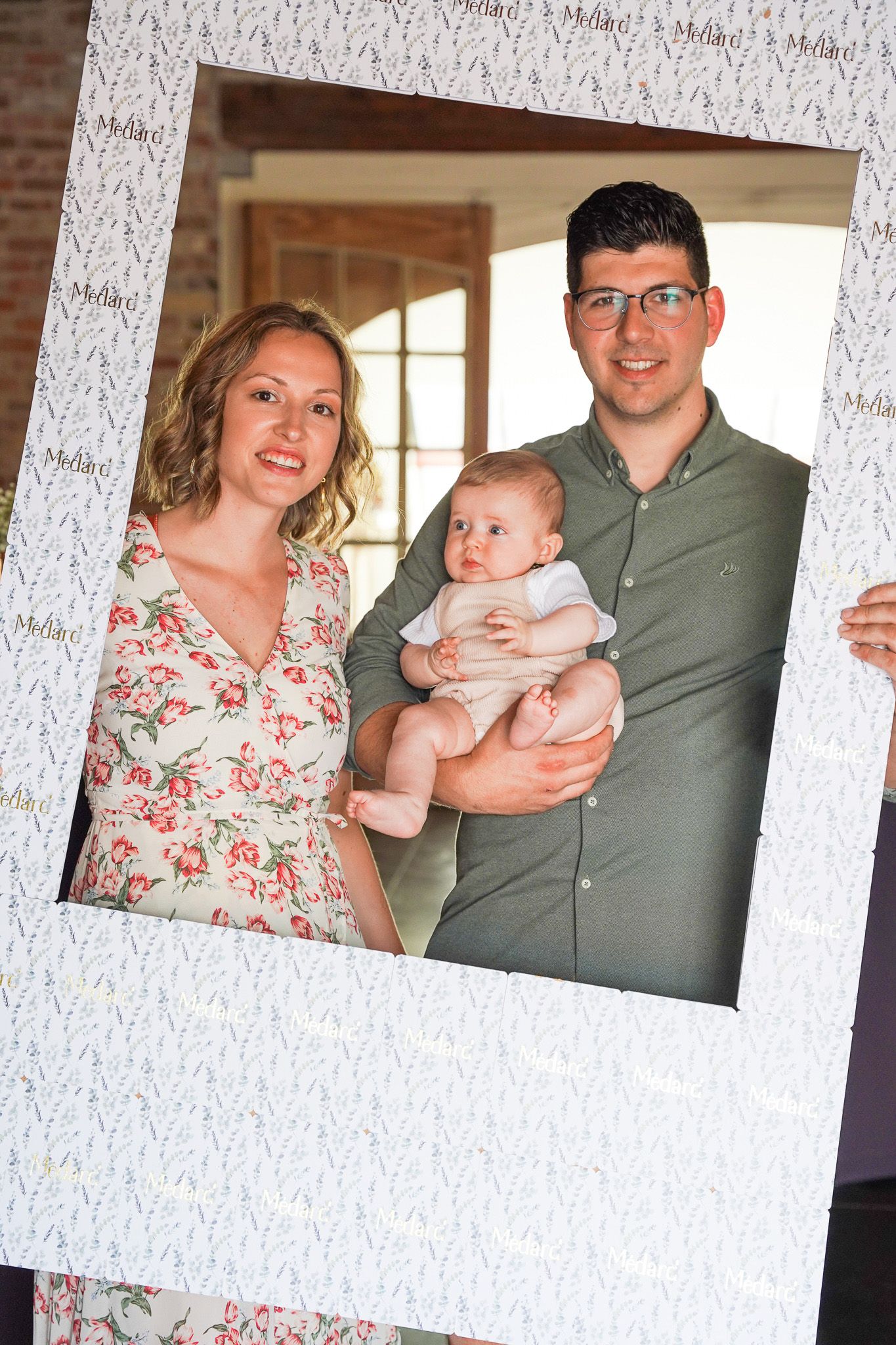 Family portrait through white textured frame against brick wall background.