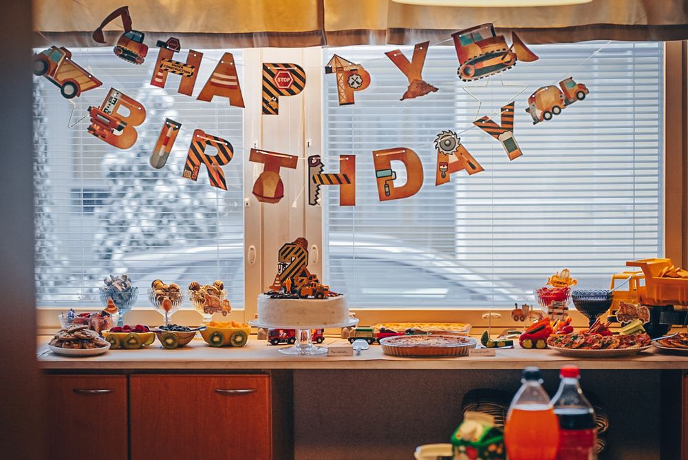 Birthday party setup with orange banner and snacks displayed on counter.
