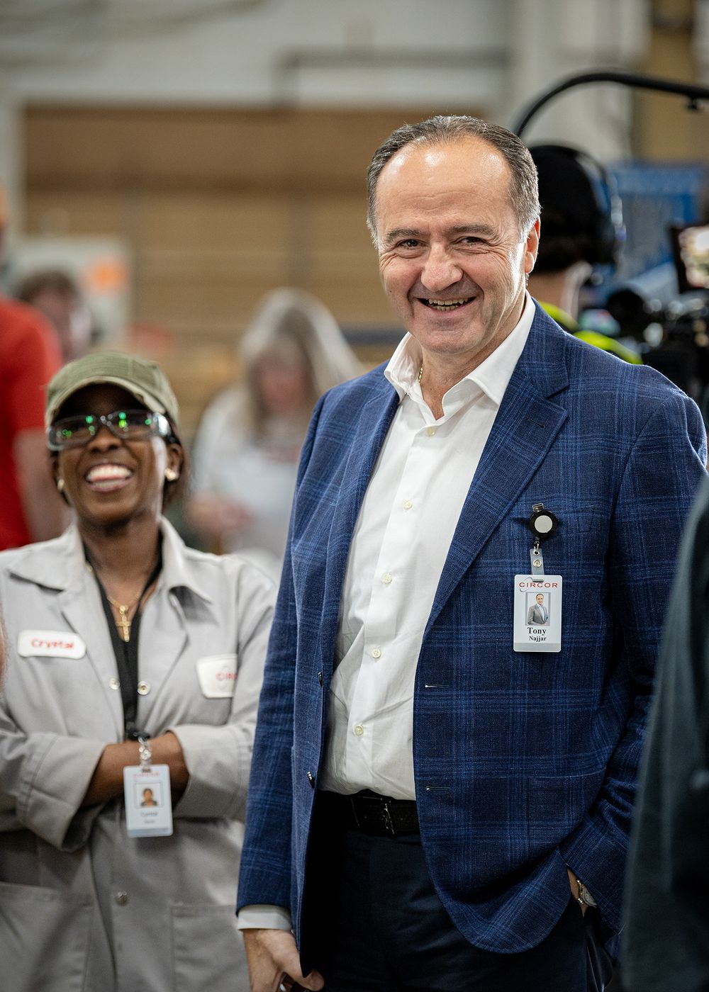 Business professionals in suits sharing laughs during a workplace gathering.
