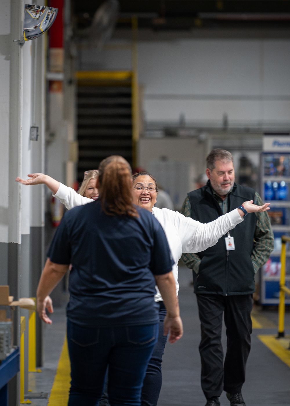 Group of employees engaged in team building exercises in a warehouse space.