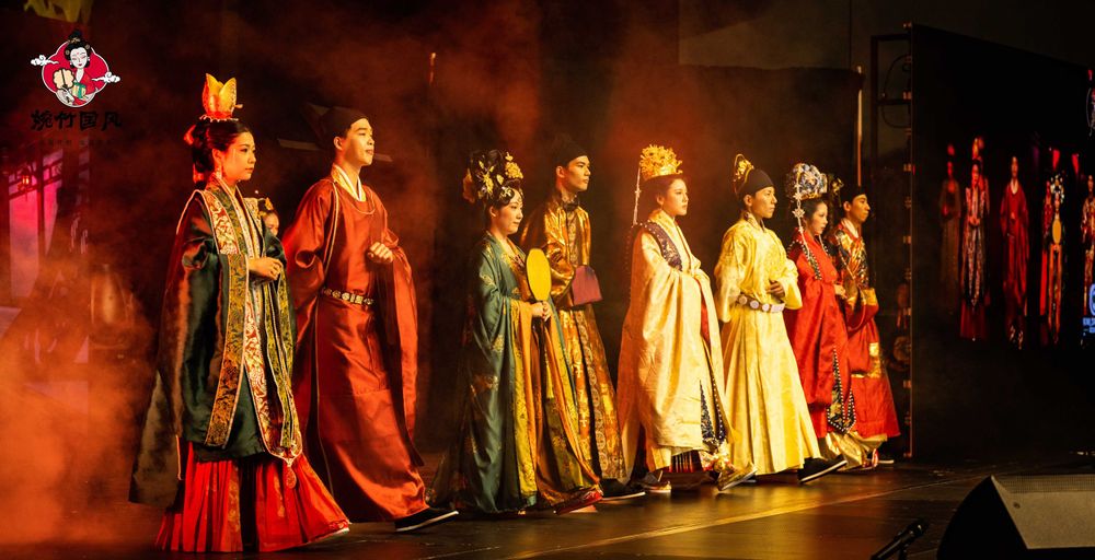 Dramatic stage photography of a traditional Hanfu fashion show featuring elegant performers, by an Auckland event photographer.
