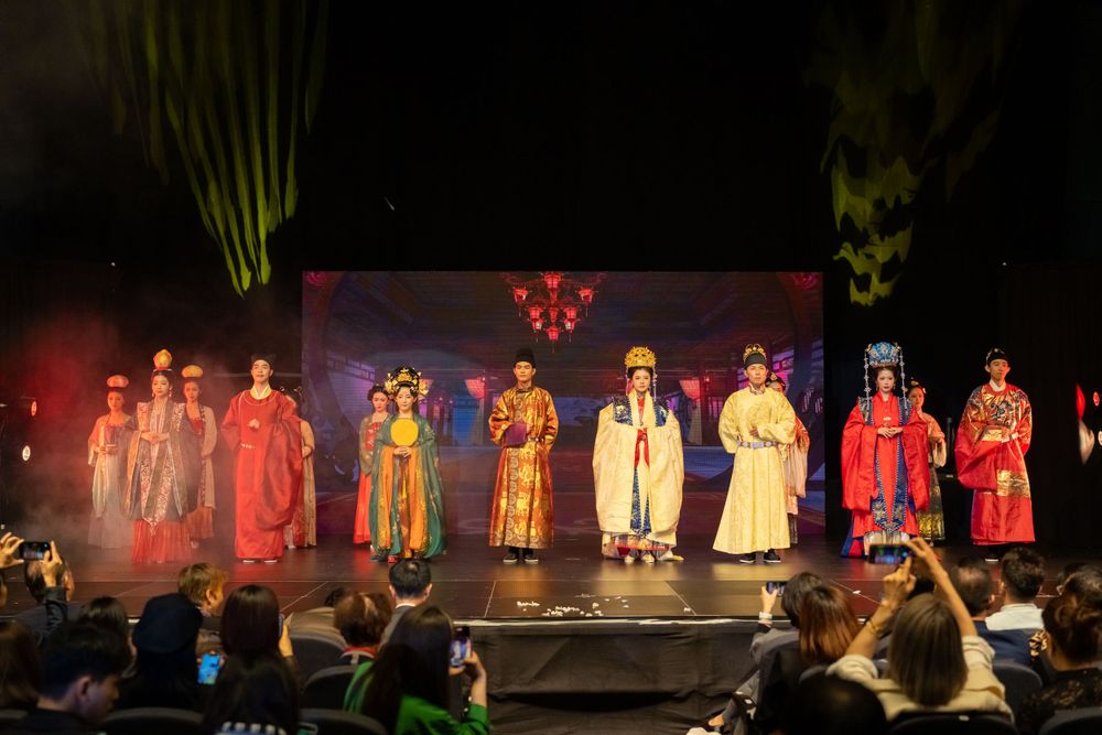 Dramatic stage photography of a traditional Hanfu fashion show featuring elegant performers, by an Auckland event photographer.
