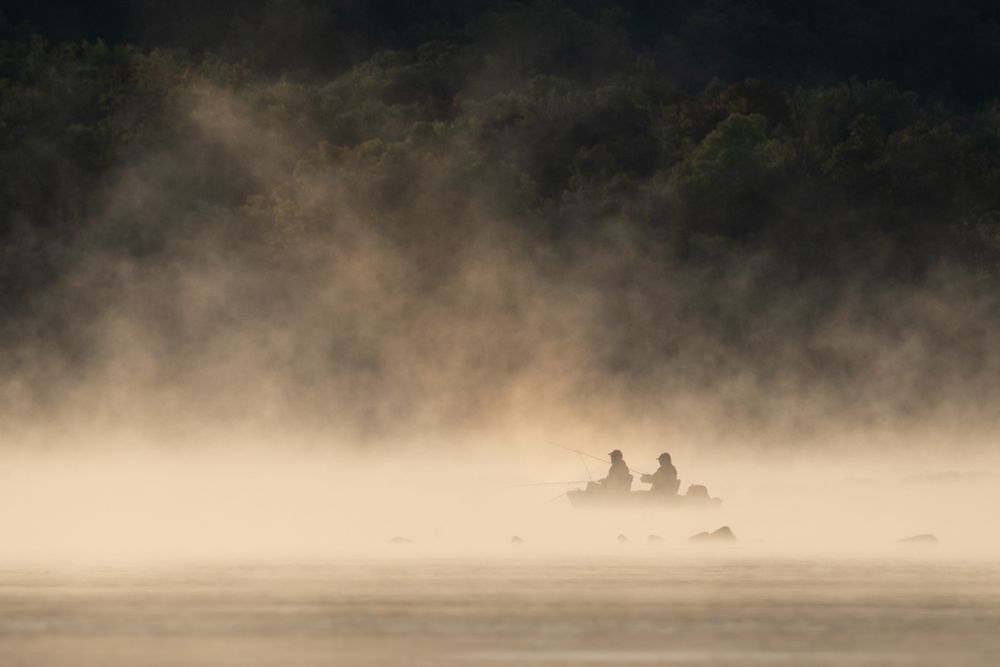 Foggy morning at Conowingo dam, two fishermen in boat