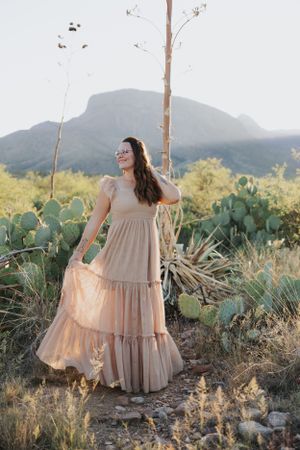 Desert fashion shoot with flowing dress and natural mountain backdrop.