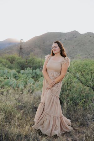 Ethereal desert fashion photography featuring a light colored tiered dress against rugged mountain landscape.
