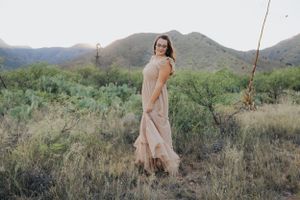 Natural desert landscape serves as backdrop for flowing dress photography session.