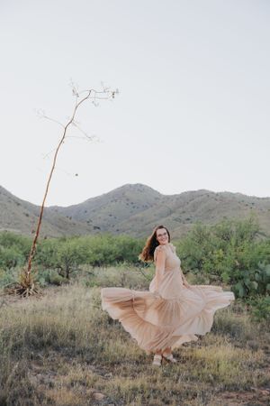 Whimsical desert photoshoot featuring a spinning dress with mountains in the background.