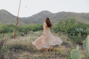 Artistic desert portrait session featuring flowing fabric movement against mountain scenery.