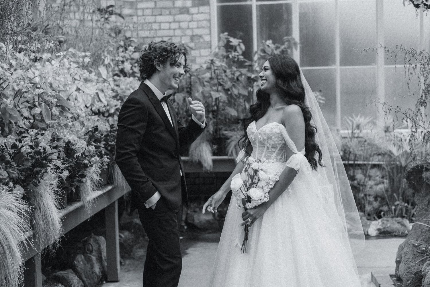 Black and white wedding photo series showing romantic moments between bride and groom against a brick wall.
