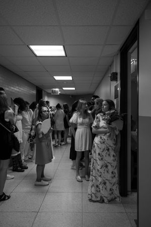 The waiting area outside Chicago's City Hall Marriage Court is revealed to be a dim basement hallway full of people (B&W).