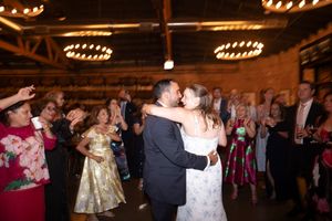 A newlywed couple together on the dance floor surrounded by friends.