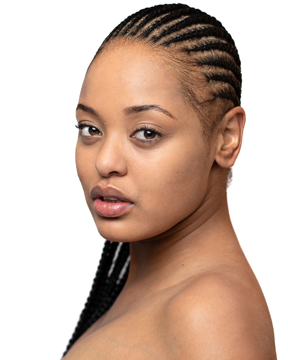Beauty portrait showcasing intricate cornrow braided hairstyle against white background.